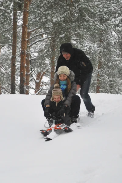 Família em um passeio em uma floresta coberta de neve de inverno . — Fotografia de Stock