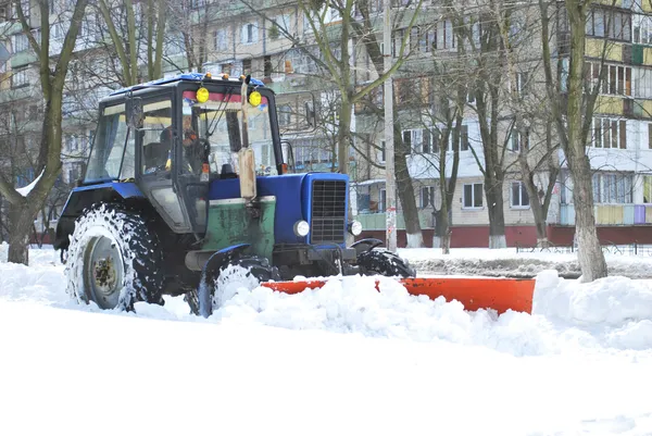 tractor cleans snow on the street