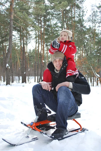 Invierno en el bosque papá sosteniendo a su hijo sobre sus hombros . — Foto de Stock