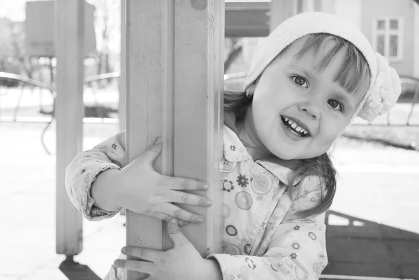 Ein kleines Mädchen spielt auf dem Spielplatz und lacht. — Stockfoto