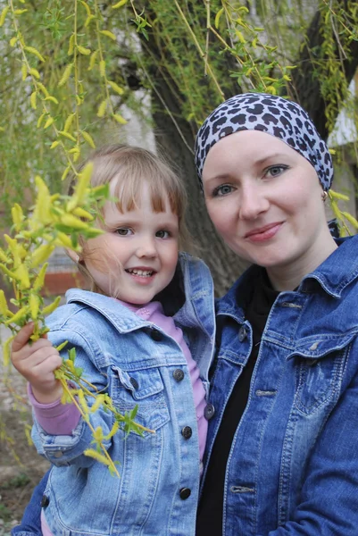 Mom with her daughter standing near willow — Stock Photo, Image