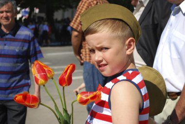 ragazzo si congratula con veterani, il giorno della vittoria e vuole dare il flusso