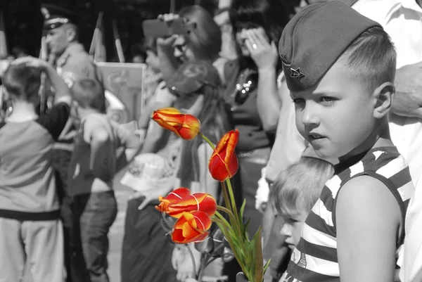 Boy congratulates veterans on Victory Day and wants to give fl — Stock Photo, Image