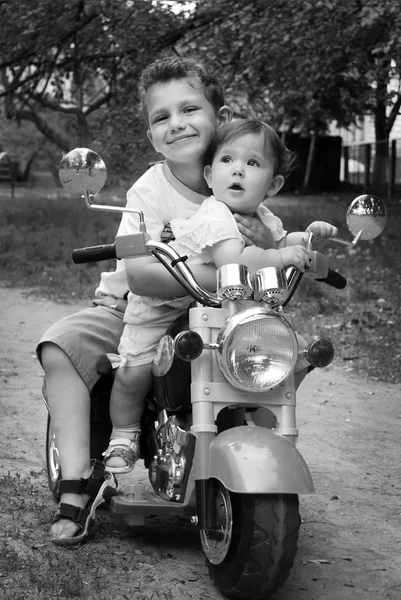 On the street hugging brother little sister, they ride on a mot — Stock Photo, Image