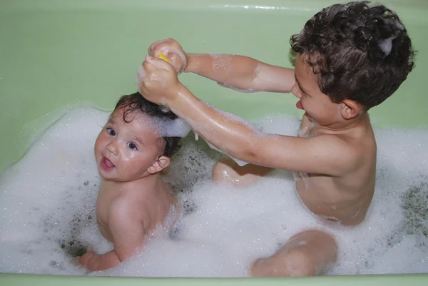 Brother and sister bathed in a bubble bath.