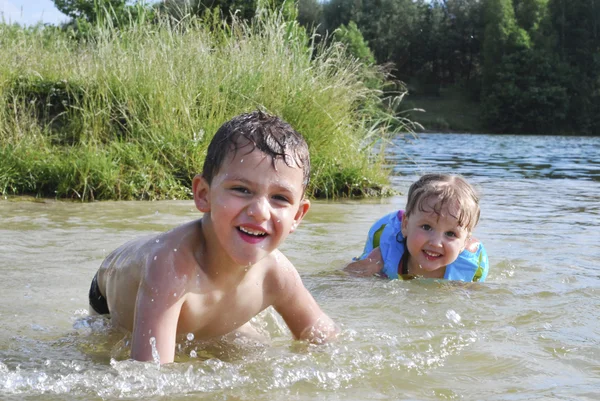 En verano, el río complacer a niño y niña, que están alcanzando —  Fotos de Stock