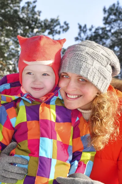 Mamá e hija bebé en un bosque cubierto de nieve . — Foto de Stock