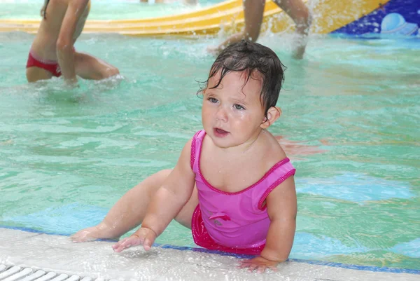 Klein meisje in het waterpark bij het zwembad. — Stockfoto