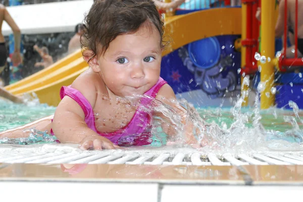 Klein meisje in het waterpark bij het zwembad. — Stockfoto