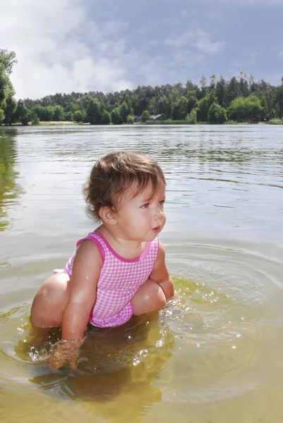 小さな女の子は、川で泳ぎます. — ストック写真