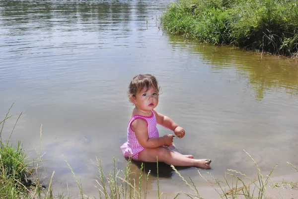 Une petite fille nage dans la rivière . — Photo