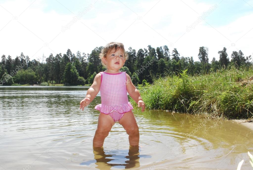 a little girl swims in the river.