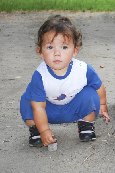 Niña juega con una piedra en la calle . — Foto de Stock