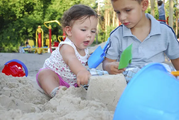 Hermano y hermana jugando en la arena en el patio . — Foto de Stock