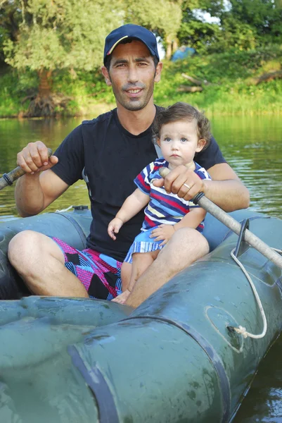 Dad with little daughter sitting in a boat on the river. — Stock Photo, Image