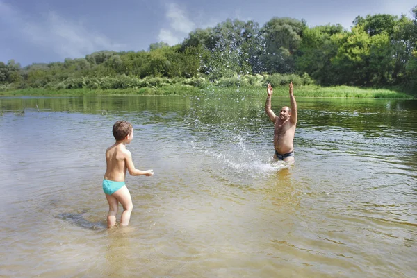 Sommer auf dem Fluss Vater und Sohn schwimmen, streut. — Stockfoto