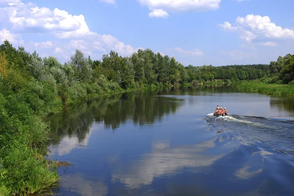 Landskap. båt med människor flyter i floden. — Stockfoto