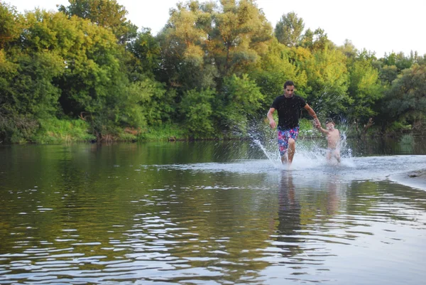 Verano en el río padre e hijo nadando, espolvorea . — Foto de Stock