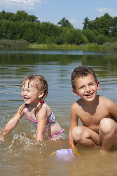 Jeunes enfants jouant sur la plage près du lac . — Photo