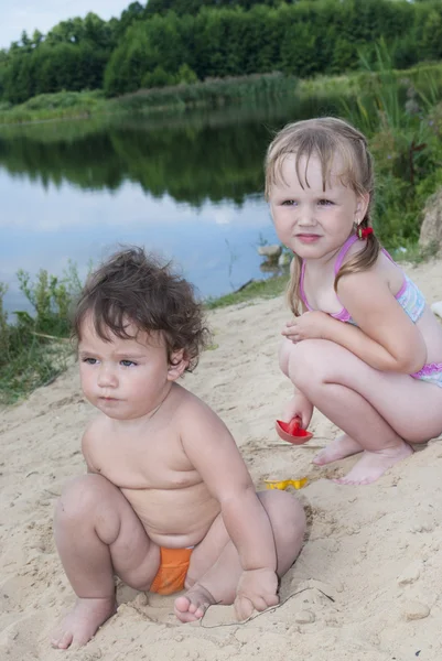 Młody dzieci bawiące się na plaży w pobliżu jeziora. — Zdjęcie stockowe