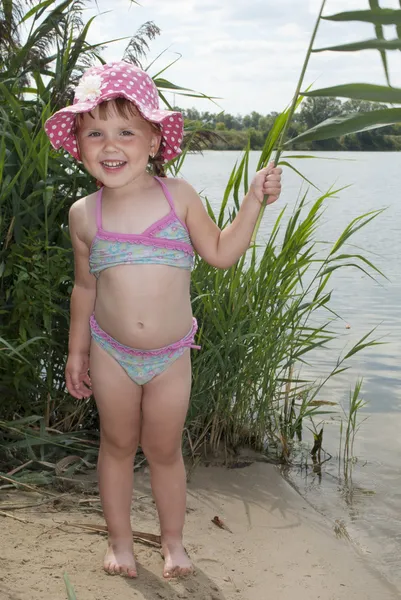 Lato nad jeziorem w pobliżu stroiki mały dziewczyna w kapeluszu panama. — Zdjęcie stockowe