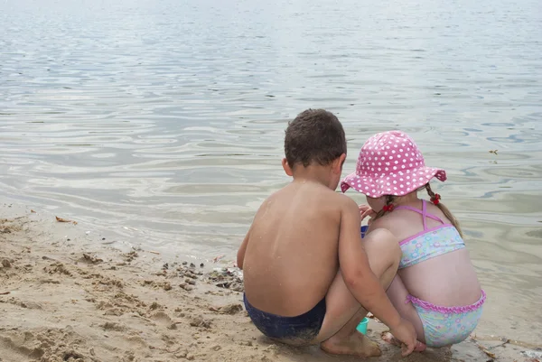 Crianças brincando na praia perto do lago . — Fotografia de Stock