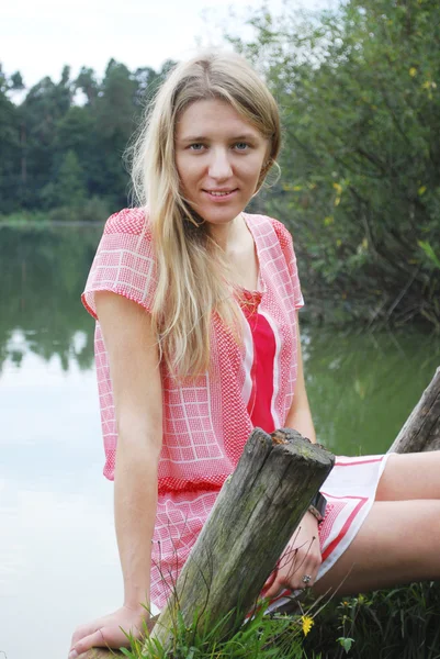 Chica sentada en la orilla del lago en el árbol . —  Fotos de Stock