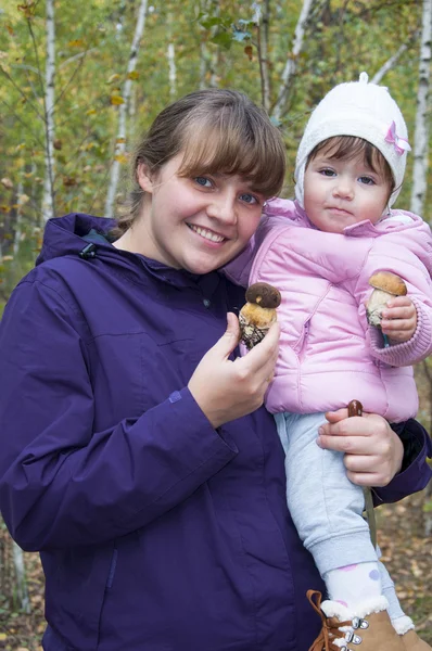 Mama i córeczka w lesie są gospodarstwa grzyby. — Zdjęcie stockowe