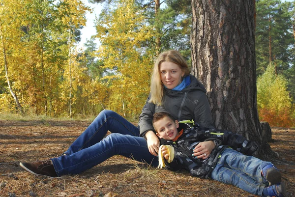 Mor och son i höst skog. — Stockfoto