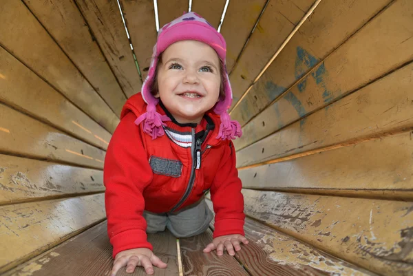 Ein kleines Mädchen spielt auf dem Spielplatz und lacht. — Stockfoto