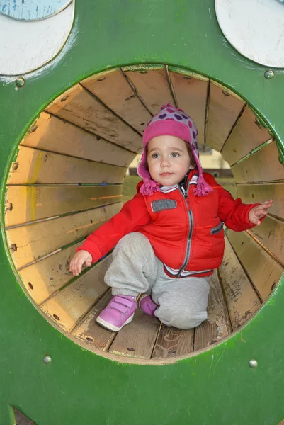 Una bambina che gioca al parco giochi e ride . — Foto Stock