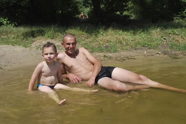Батько і син плавають у річці . — стокове фото