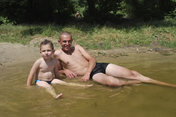 Vater und Sohn schwimmen im Fluss. — Stockfoto