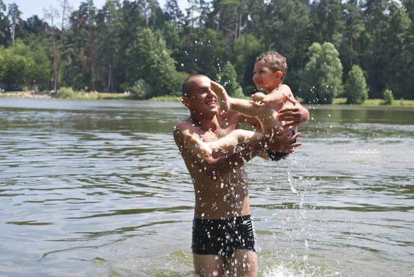 Vater und Sohn schwimmen im Fluss. — Stockfoto