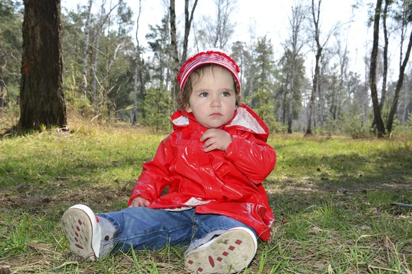 Malá dívka sedící v lese. — Stock fotografie