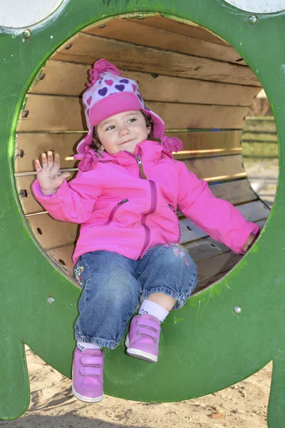 A little girl playing on the playground and laughs. — Stock Photo, Image