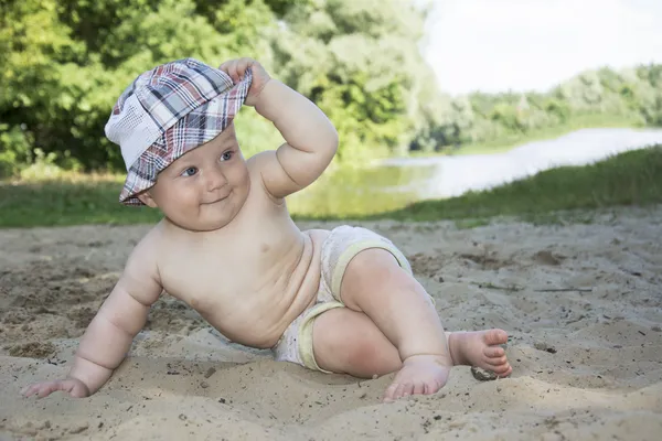 Verano en la playa cerca del río se sienta niño divertido y — Foto de Stock