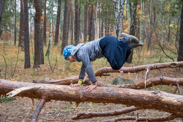 Boy Jumping Log Autumn Pine Forest — Stock fotografie