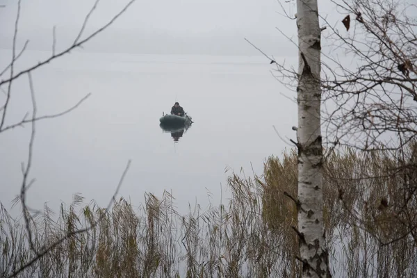 冬は寒い灰色の日に 膨脹可能なボートの漁師が魚を捕まえる — ストック写真