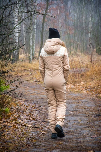 Sonbahar Ormanında Tulumlu Şapkalı Bir Kız Yol Boyunca Yürür — Stok fotoğraf