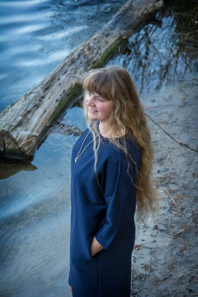 在一个寒冷的秋日 湖上站着一个长头发的漂亮姑娘 — 图库照片