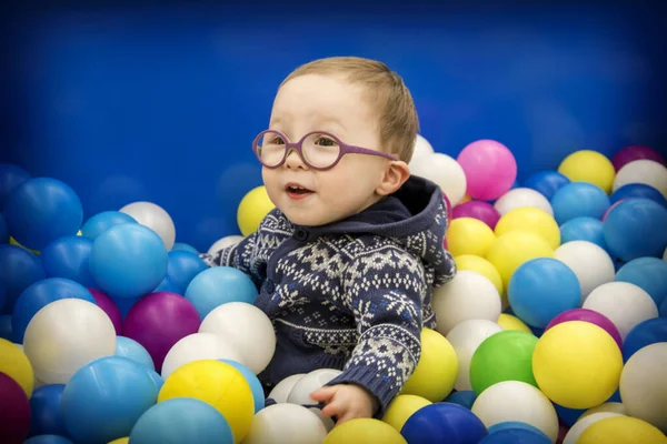 Маленький Хлопчик Синьому Светрі Окулярах Грає Різнокольоровими Пластиковими Кульками Ігровій — стокове фото