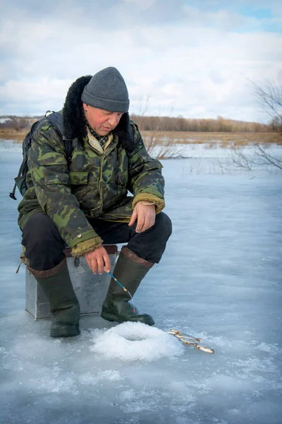 Μια Παγωμένη Μέρα Χειμώνα Ένας Άντρας Κάθεται Στο Ποτάμι Ψαρεύοντας Royalty Free Εικόνες Αρχείου