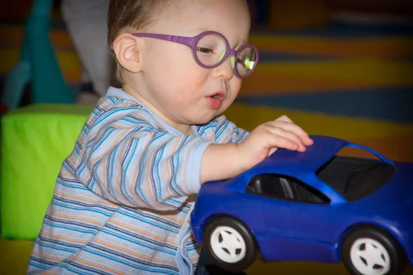 Menino Com Óculos Brinca Com Carro Brinquedo Azul Sala Jogos — Fotografia de Stock