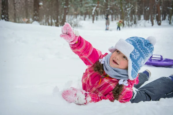 Winterwald Auf Dem Schnee Liegt Ein Kleines Lustiges Mädchen Und — Stockfoto