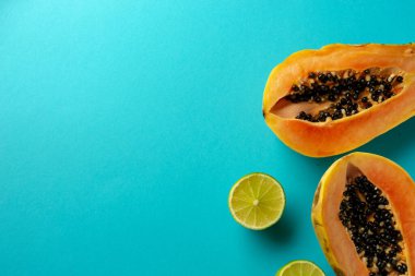 Yaz kompozisyonu. Tropikal kireç ve papaya meyveleri mavi arka planda yatar. Yaz kavramı. Düz konum, üst görünüm, kopyalama alanı.