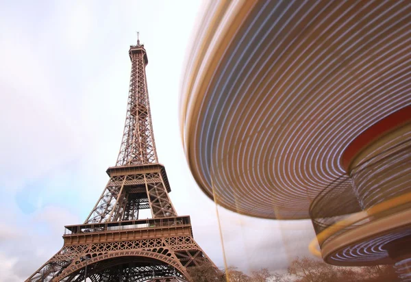 Carrusel iluminado en movimiento frente a la Torre Eiffel, París, Francia — Foto de Stock