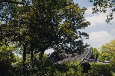 Mütevazı Yöneticinin Bahçesi (Zhuozhengyuan) Suzhou, Çin 'deki ağaçlar arasında geleneksel mimari