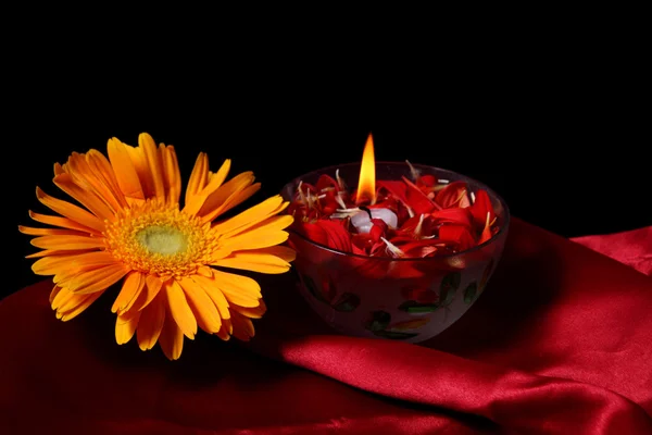 Płomień wewnątrz miski płatków kwiatów na tkaniny aksamitne — Zdjęcie stockowe