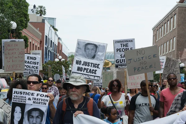 Manifestantes portaban pancartas en apoyo a Trayvon y otras víctimas de la violencia . — Foto de Stock